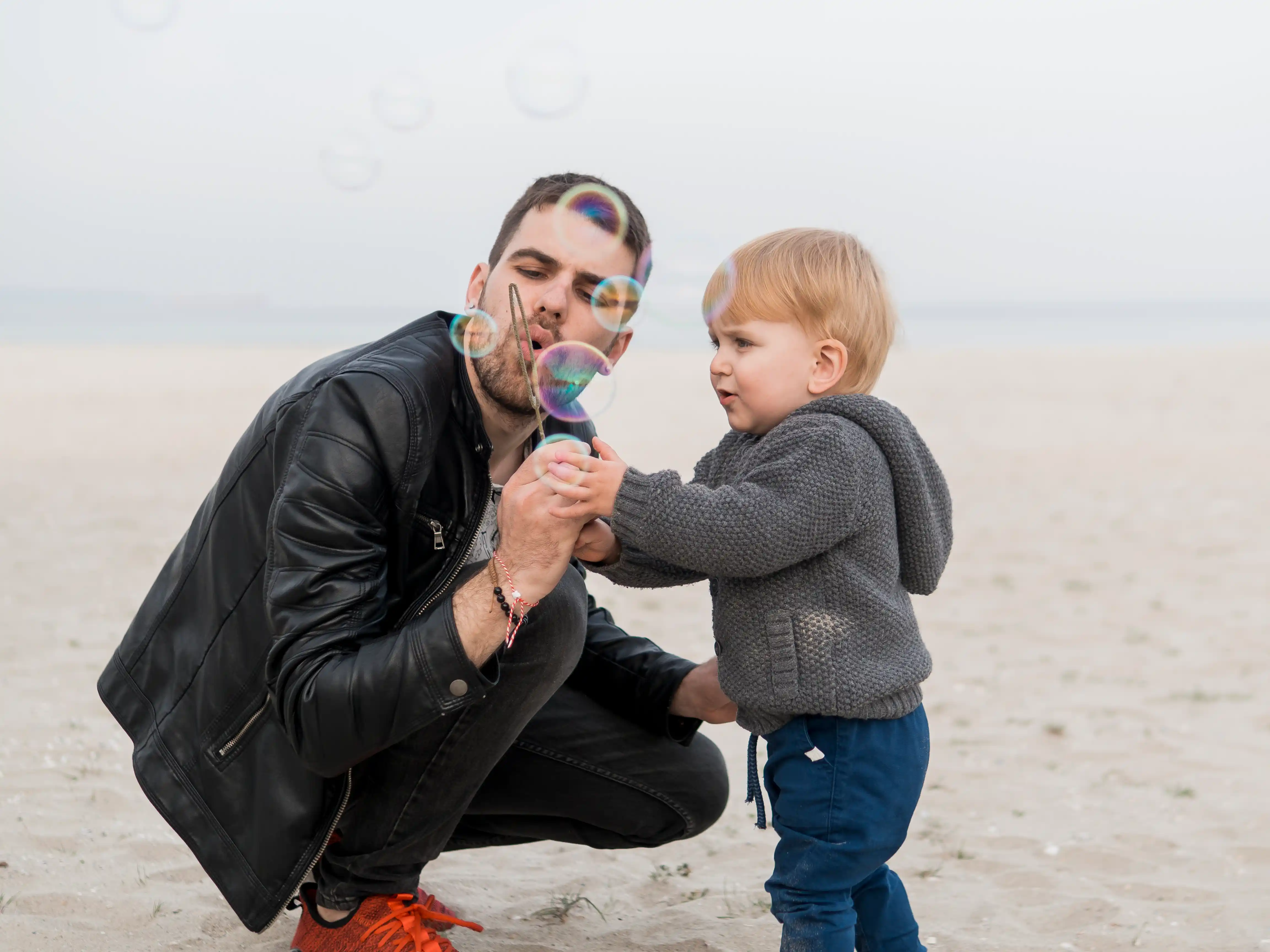 1 father-son-making-soap-bubbles-beach